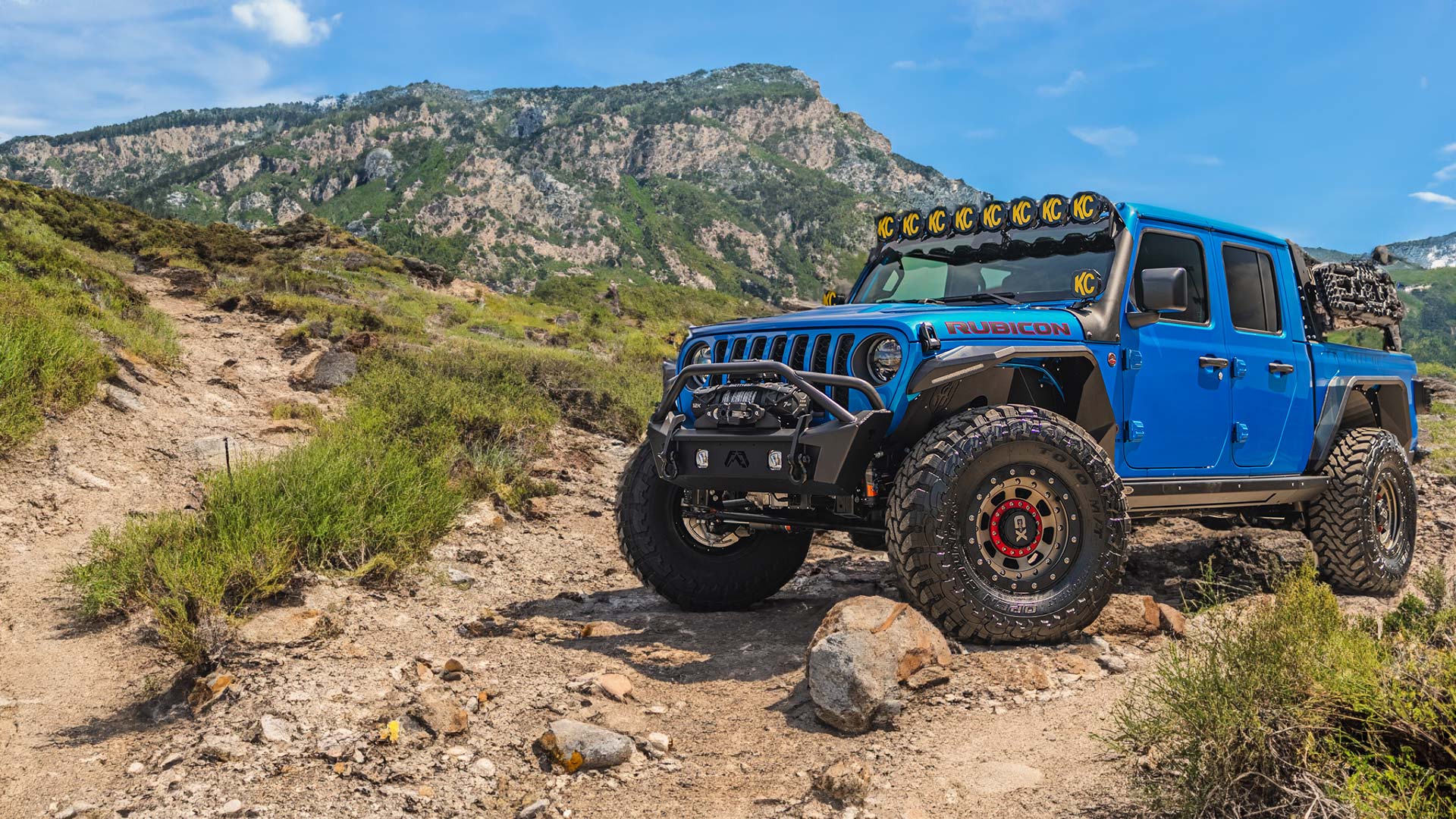 Blue Jeep on Rocky Trail in Mountains
